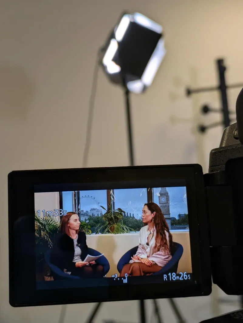 A close-up of the interview on the camera monitor, with the recording light above.